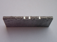A linotype “slug” is a block of lead that has letter shaped extrusions on one side. (Image source: Wikimedia CC by-SA)